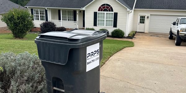 Trash bin outside a suburban house.
