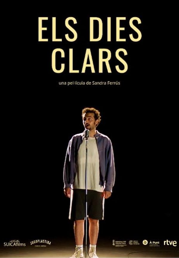 Póster de la película "Els Dies Clars" con un hombre frente a un micrófono.