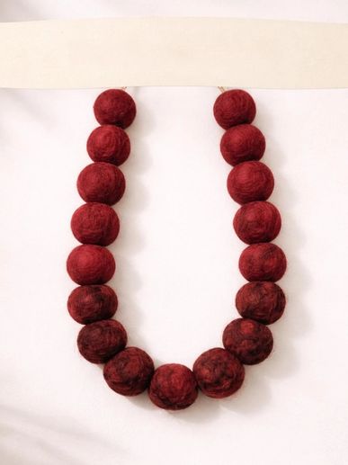 A necklace made of large, round, deep red beads.
