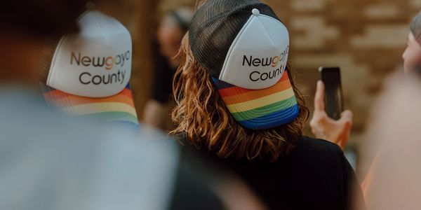 People wearing Newgaya County caps with rainbow designs.