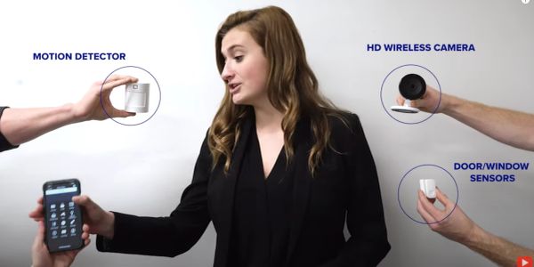 Woman with home security devices and smartphone.