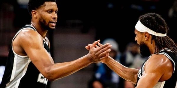 Two basketball players high-fiving during a game.