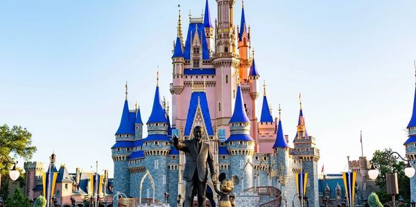 Disney castle with statue of Walt Disney and Mickey Mouse.