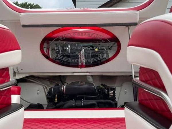Red and white boat interior with visible engine and performance branding.