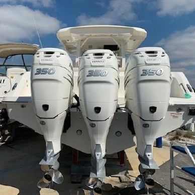 Boat with three white 350 horsepower outboard motors.