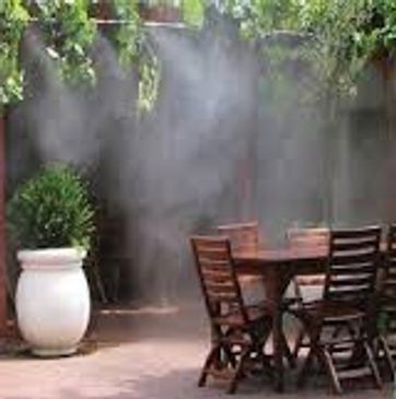Outdoor patio with wooden furniture and misting system.