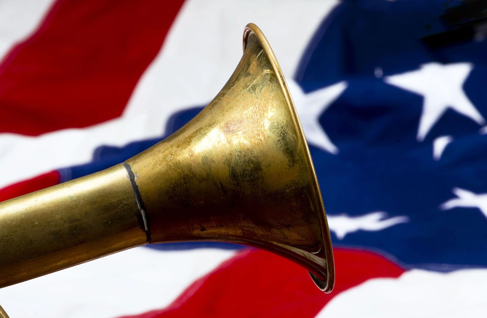 A bugle in front of an American flag.
