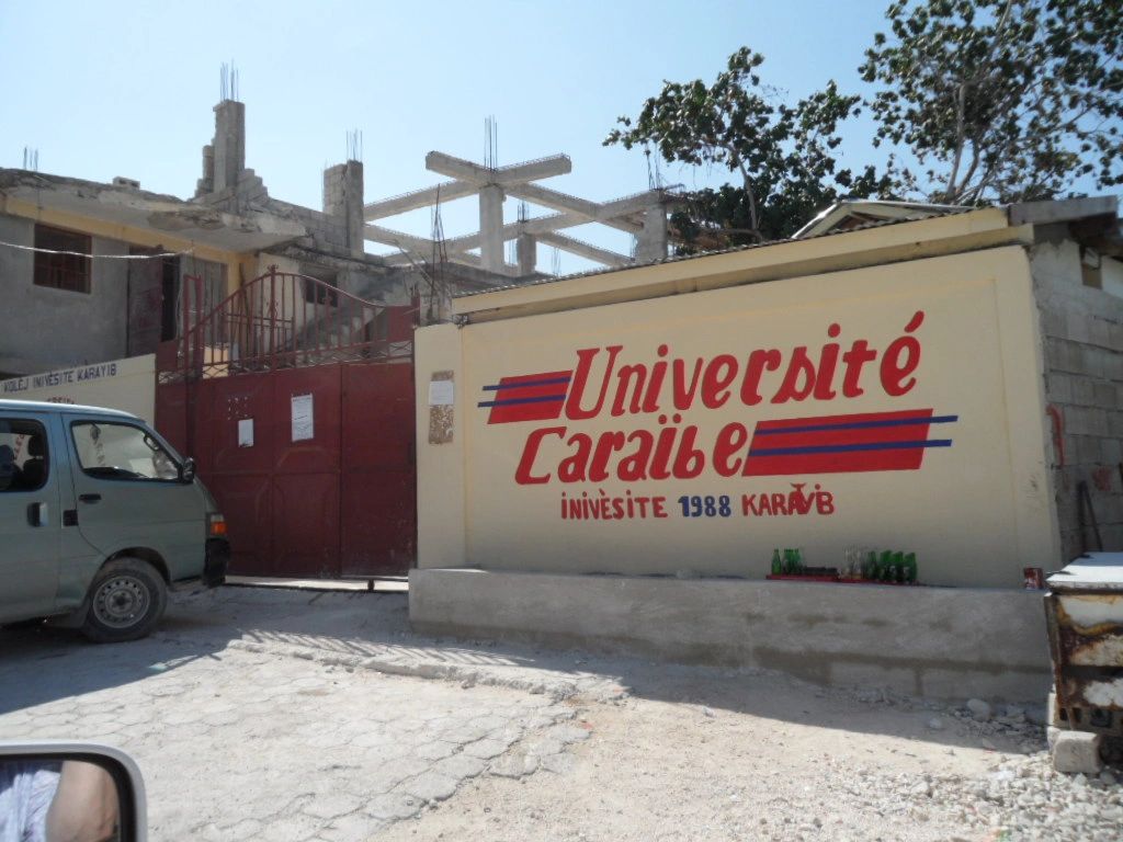 Entrance of Université Caraïbe with a van parked nearby.