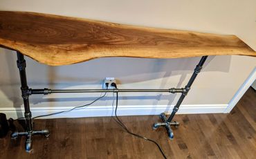 BAR TABLE MADE WITH A LIVE EDGE WALNUT SLAB WITH CAST PIPE LEGS AND STRETCHER