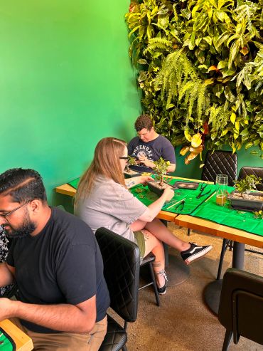 People creating plant arrangements at a workshop.