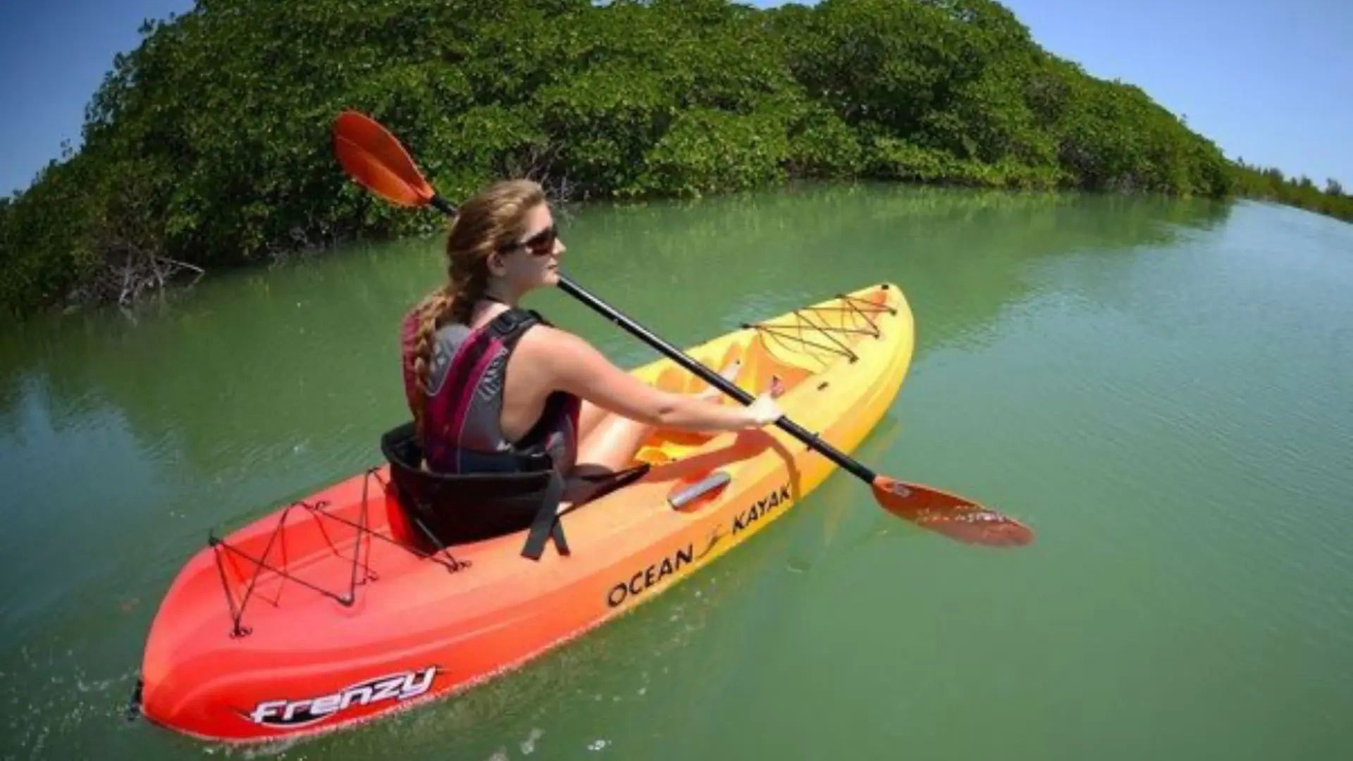 Woman kayaking solo through calm mangroves in Cape Coral, Florida.