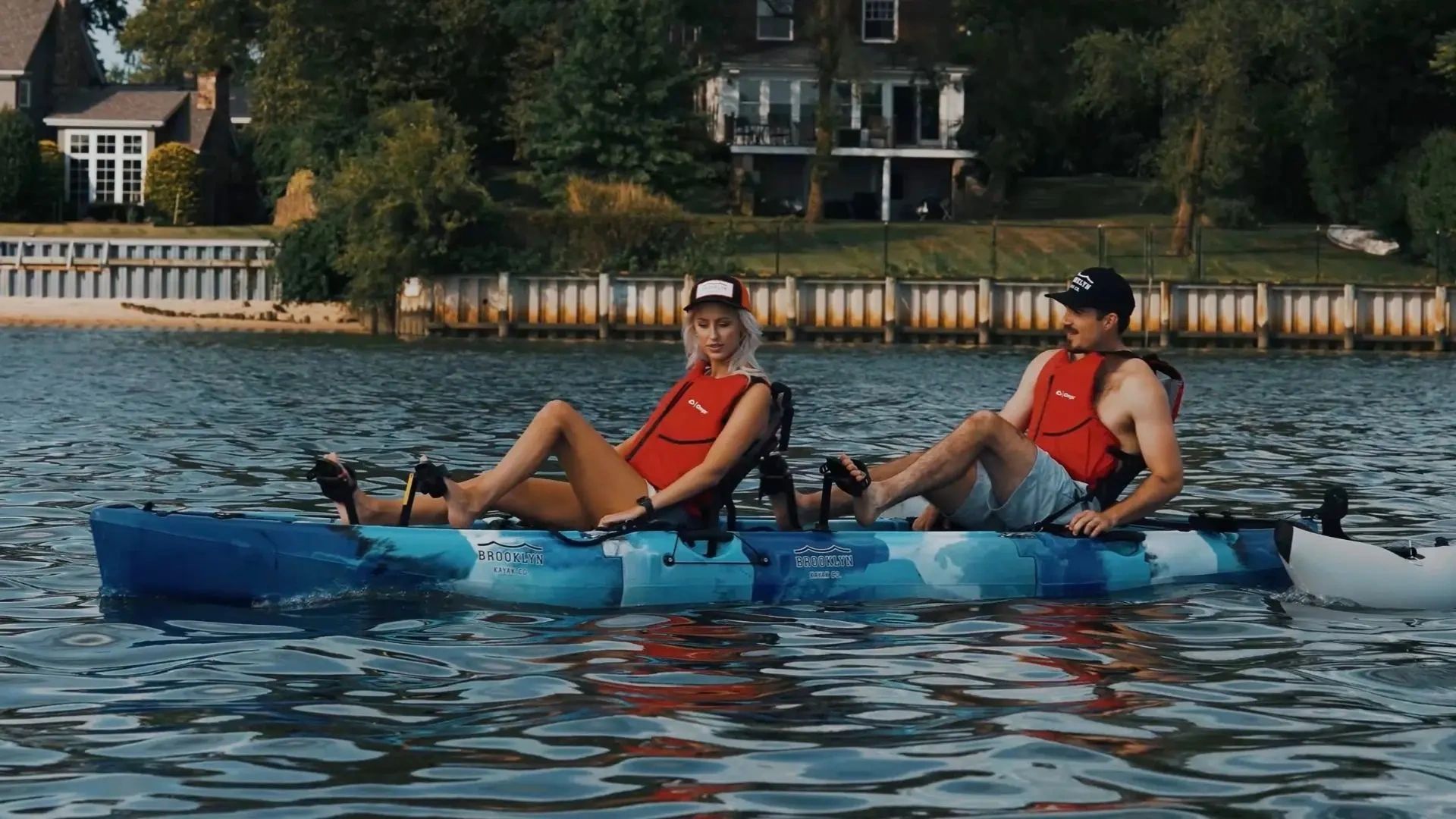 Couple cruising in a tandem pedal kayak on calm water in Cape Coral, Florida. 