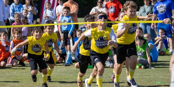 Young boys race to cross the finish line in a community sports event.