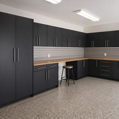 Modern garage with sleek black cabinets and wooden countertop.