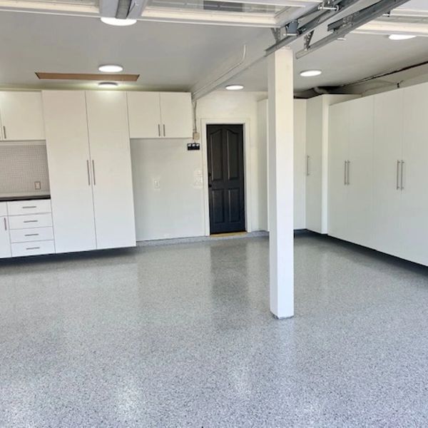 Clean, organized garage with white cabinets and polished floor.