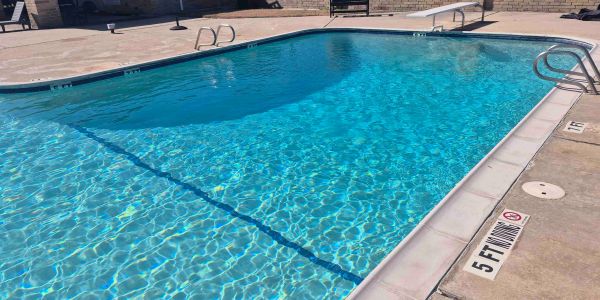 Clear blue swimming pool with 5-foot depth marking.