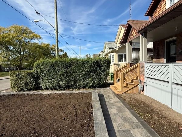 Newly paved walkway and garden bed beside a suburban house.