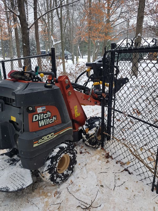 Ditch Witch machine fitting easily through a backyard gate.