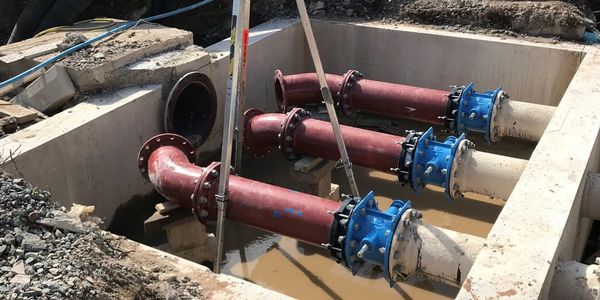 Compact surface water discharge pipework arrangement with non-return valves.