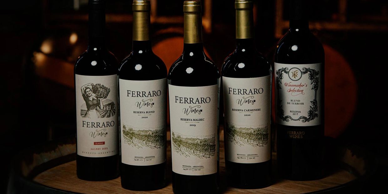 Five bottles of Ferraro Wines displayed on a wooden barrel.