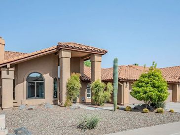 Single-story house with a desert-style front yard and a tall cactus.