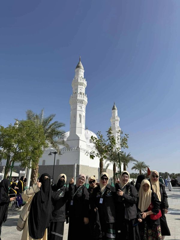 Group of women in front of a mosque on a sunny day.