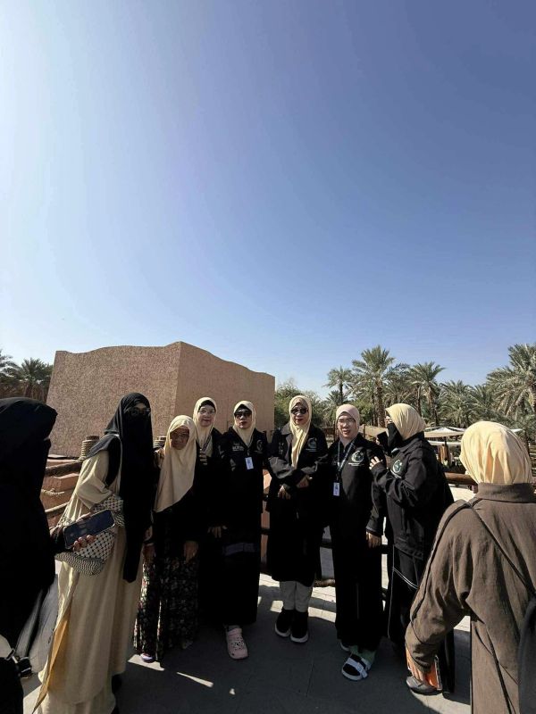 Group of women wearing headscarves and black jackets outdoors.