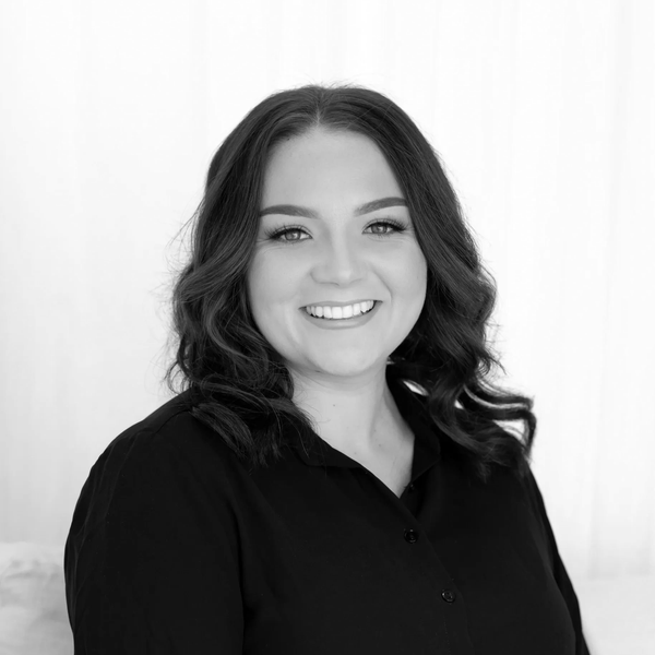 Smiling woman with dark hair in black blouse.