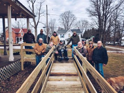 Group photo on a wooden ramp in a neighborhood.
