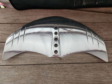 Polished metallic wing-shaped object with holes.