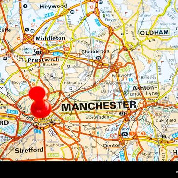 Red pin marking Manchester on a detailed road map of surrounding areas.