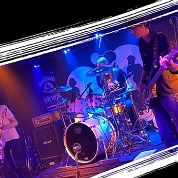 Live band performing on stage with vibrant blue and orange lighting.