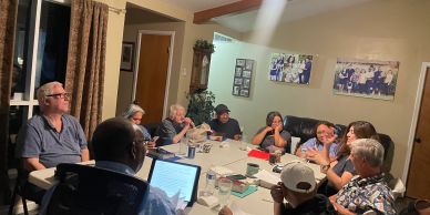 Group of people gathered around a table in a meeting.