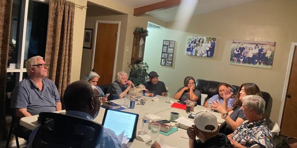 Group gathered around table in discussion.