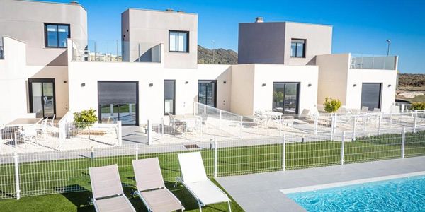 Modern houses with a pool and lounge chairs.