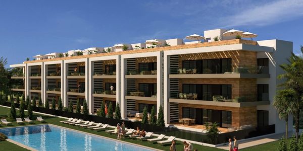 Modern apartment building with a pool and sun loungers.