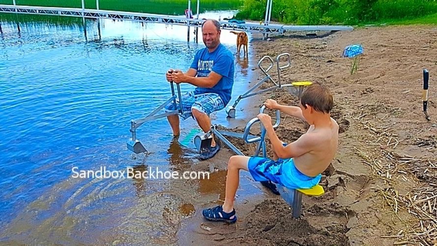 alt="dad and boy playing on higley sandbox digger backhoe."