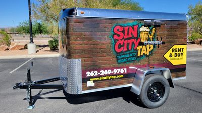 Mobile beer tap trailer with colorful Sin City Tap branding and contact info.
