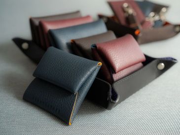 Close-up of leather coin pouches in dark blue and maroon colors.