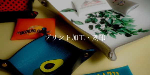 Colorful leather trays with various prints and Japanese text in the center.
