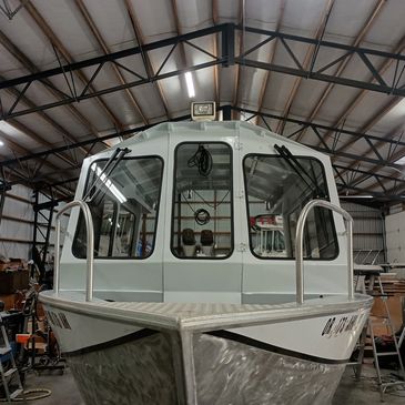 Front view of a cabin boat inside a warehouse.