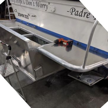 Boat with a custom aluminum platform being worked on indoors.