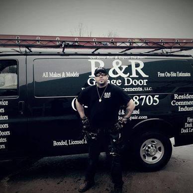 Man standing confidently in front of a P&R Garage Door service van with a ladder on top.