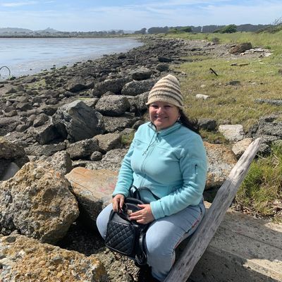 Nina sitting by the shore on sunny day.