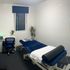 A cosy and professional massage therapy room with a heated bed, soft lighting, and calming decor.