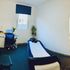  A well-prepared massage room featuring a heated bed, clean linens, and a calming ambiance.
