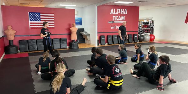 Group of kids and teens learning about self defense.