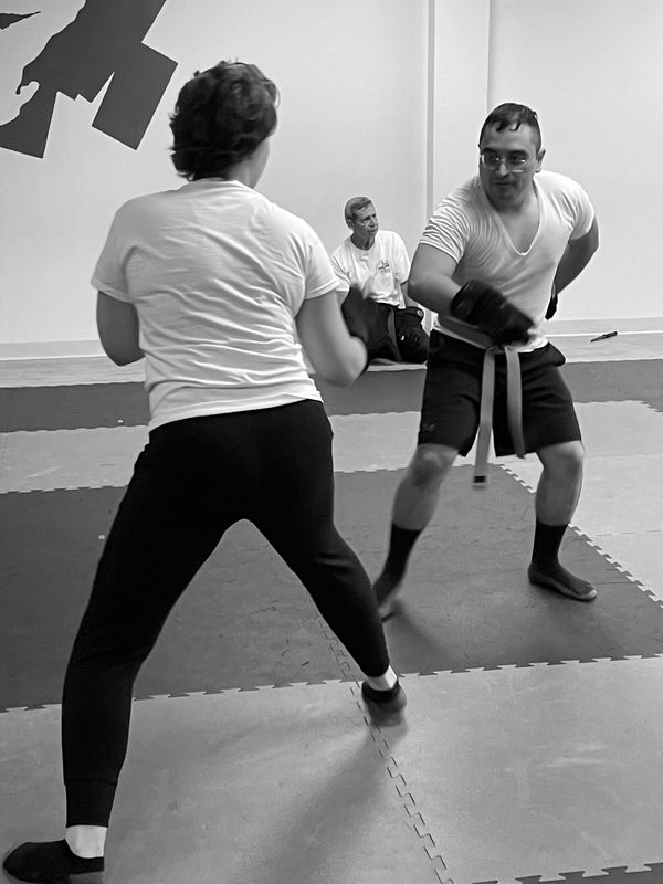 Two knife fighting training adults as they spar.