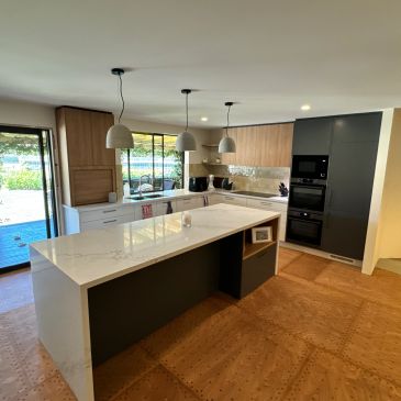 Modern kitchen with white countertops and wooden cabinets.