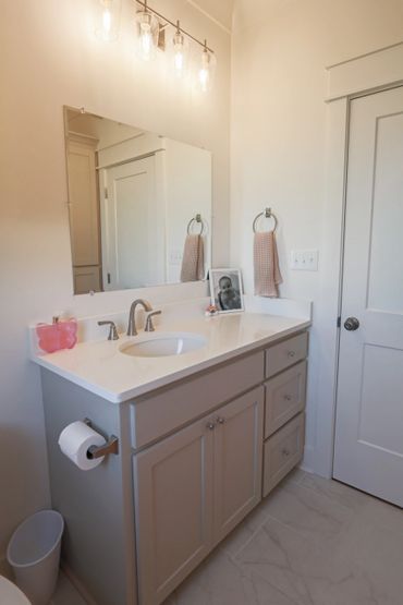 Clean, modern bathroom vanity with white countertop and soft lighting.